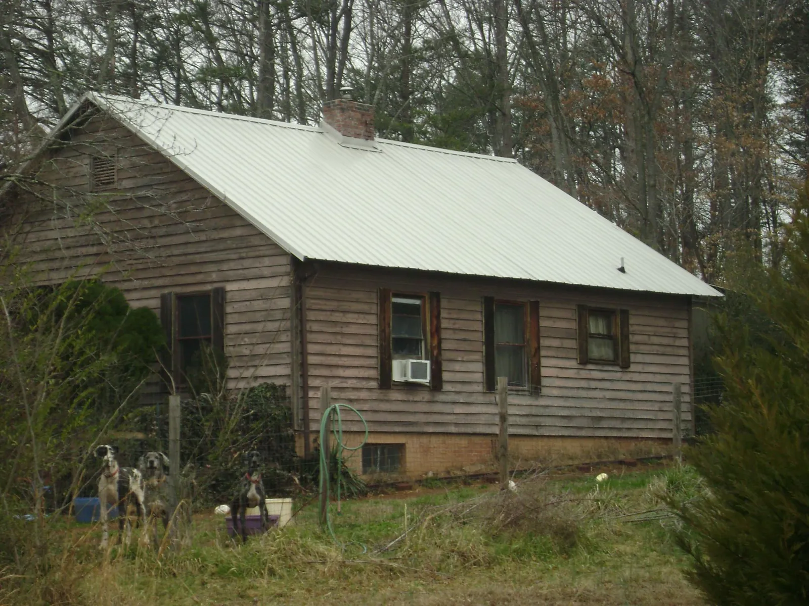 White metal roof on an old wood sided farmhouse, from a Metal Roof Installation job in Quinby